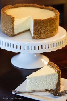 a piece of cheesecake on a white plate with a fork next to the pie