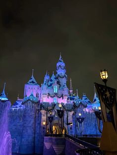 the castle is lit up with purple lights