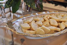 a platter filled with cut up pieces of food next to a glass vase on a table