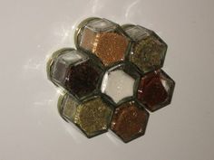 several different types of spices in glass containers on a white table top with water droplets