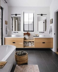 a bathroom with two sinks, mirrors and a bathtub in the middle of it