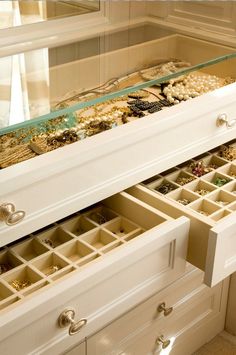 a white dresser with drawers filled with jewelry