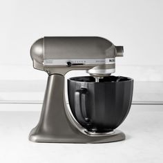 an image of a kitchen mixer on a white table with no one in the photo