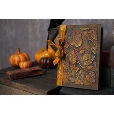 a card that has been decorated with leaves and pumpkins on the table next to it