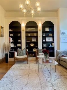 A living room featuring arched bookcase. Bookshelf With Sconces, French Built In Bookcase, Bookshelves With Sconces, Built In Shelves Color Ideas, Small Livingroomideas House, Arched Library Wall, Dining Room With Bookshelves, Ikea Billy Hack Ideas, Arched Built Ins Living Room