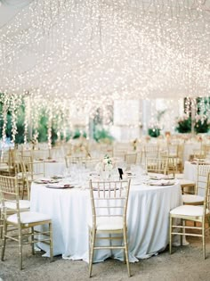 the tables are set with white tablecloths and chairs for an elegant wedding reception