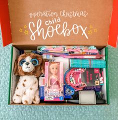 an open shoebox with toys and other items in it, including a stuffed dog