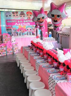 the table is set up for a birthday party with pink decorations and minnie mouse balloons