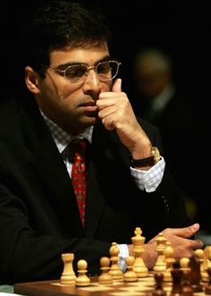 a man sitting at a chess table with his chin resting on his hand and looking to the side