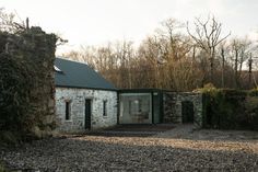 an old stone building sitting next to a forest