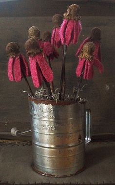 some pink flowers are in a metal cup