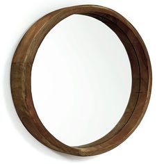 a round mirror mounted to the wall with wood trimming around it's edges