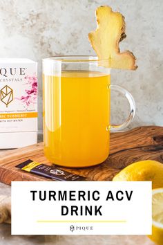 a pitcher of turmric acv drink next to some sliced lemons on a cutting board