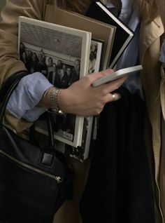 a woman is holding several books in her hands