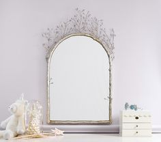 a white dresser topped with a mirror next to a stuffed animal