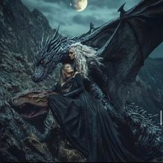 a woman sitting on top of a large dragon next to a man in black dress