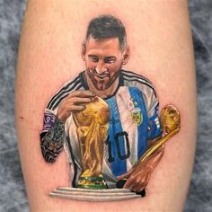 a tattoo of a soccer player holding a trophy