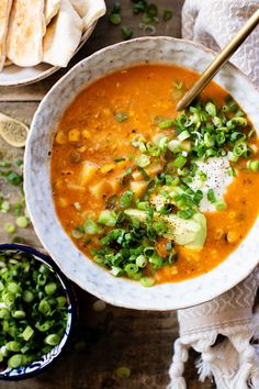 a white bowl filled with soup next to some pita bread