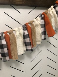 an orange and white checkered fabric is hanging from a clothes line on the wall