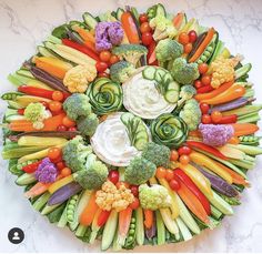 an arrangement of vegetables arranged in the shape of a circle on a marble countertop