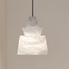 a light fixture hanging from a ceiling in a room with white walls and flooring