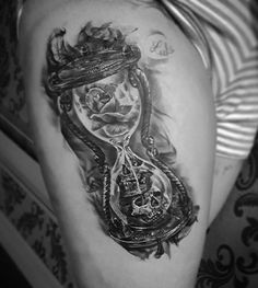 a woman's thigh with an hourglass tattoo on it