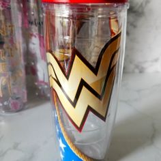 a glass cup with a red lid sitting on top of a counter next to other items