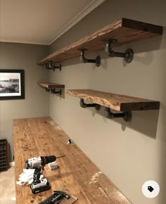 the shelves are made from wood and have pipe fittings on each shelf to hold tools