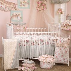 a baby crib in a room with pink walls and floral decorations on the wall