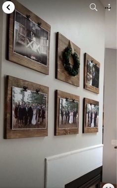 a wall with pictures hanging on it and a wreath in the middle next to them