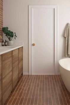 a bathroom with a bathtub, sink and brick wall in the shower area is shown