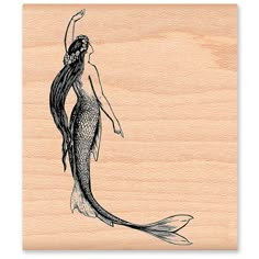 a drawing of a mermaid on wood