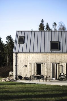 a house that has a metal roof and two windows on the side of it,