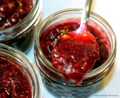 three jars filled with jam sitting on top of a table