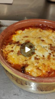 a pot filled with cheese and sauce on top of a counter next to a frying pan