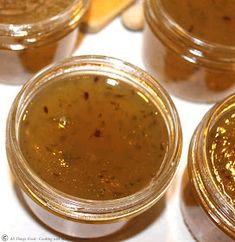 four jars filled with food sitting on top of a white countertop next to each other