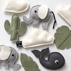 several felt elephants and cacti on a white surface