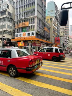 there are many cars that are stopped at the crosswalk in this busy city street