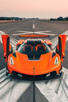 an orange sports car is parked on the runway