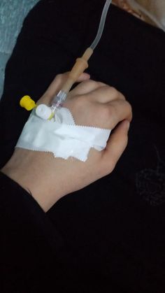 someone is holding an iv in their left hand and wrapped in white paper with a yellow rubber band