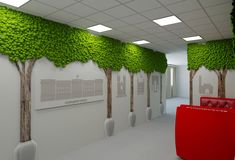 an office with green trees on the wall and red couches in front of it