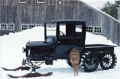 an old fashioned car parked in the snow