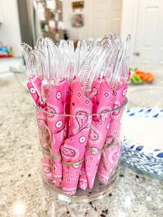 some pink napkins are in a glass vase