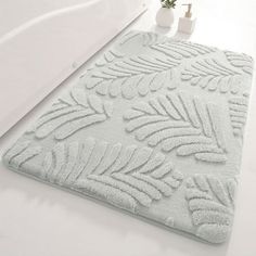 a white bath rug with leaves on it