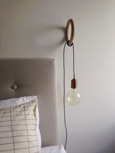 a lamp that is on the side of a bed next to a pillow and pillows