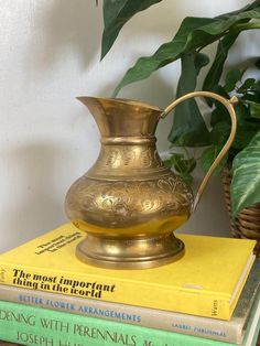 a gold pitcher sitting on top of three books