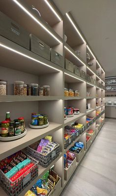 the shelves are filled with food items and have bins on each shelf for storage