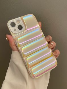 a woman holding up a phone case that has multiple iridescent strips on it