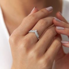 a woman's hand holding a diamond ring