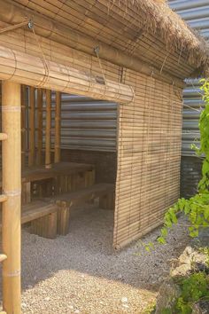 a bamboo structure with benches under it